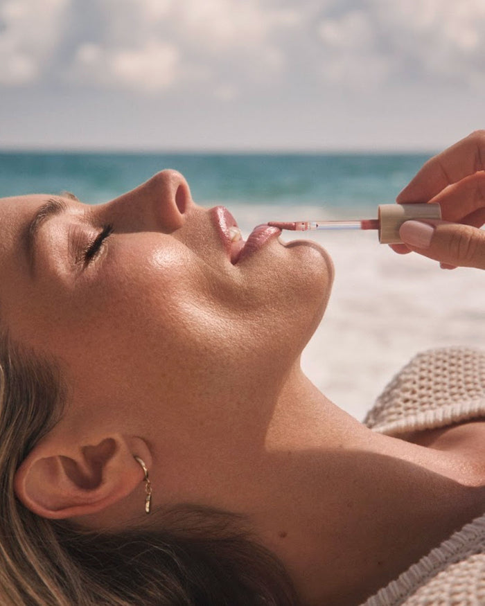 Model putting on Rel Glossy Lip Oil